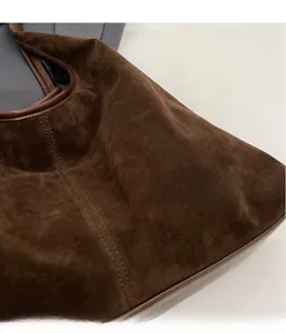 Detailed close-up of dark brown suede texture and stitching on the minimalist tote bag