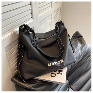 Close-up of black nylon tote bag with white MOTION text and braided rope handle