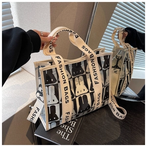 Detail der transparenten PVC-Tasche mit schwarz-weißen Hasenmustern und gewebten Riemen