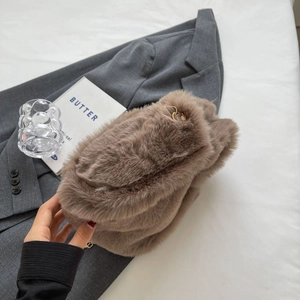 Détails de la texture pelucheuse et de la chaîne dorée du sac seau en fausse fourrure