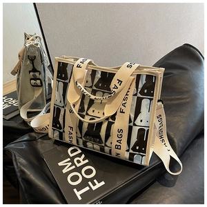 Nahaufnahme einer transparenten PVC-Einkaufstasche mit schwarz-weißen Hasenprints und Logo-Gurt