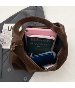 Detail view of large brown suede tote bag interior with tablet and books for commuting