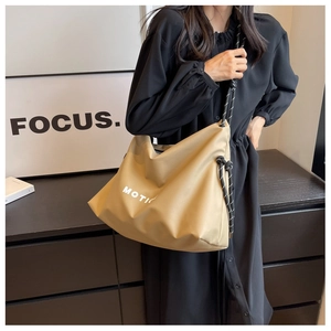 Detail view of khaki nylon tote bag with black and white woven rope shoulder strap