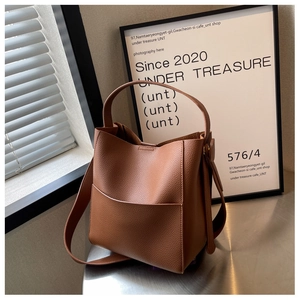 Détails de la texture du cuir marron à motif litchi et structure du sac seau