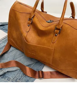 Close-up of brown PU leather travel bag texture with embossed NOCO logo and nylon strap