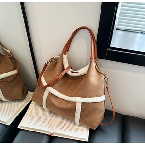 Détail du grand sac vintage en daim marron avec garniture en peau de mouton sur un livre