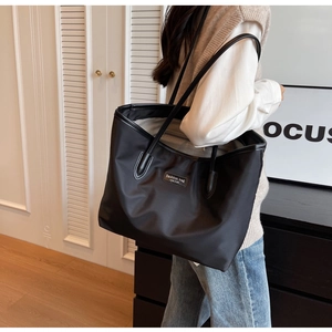 Seitenansicht eines großen schwarzen Nylon-Shoppers an einem Model für einen modernen Look