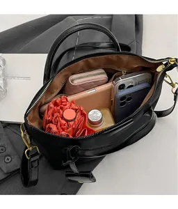Macro detail of spacious black Oxford tote interior with golden zippers and accessories