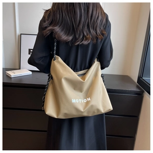 Detail of khaki nylon tote bag with white MOTION lettering and woven rope strap