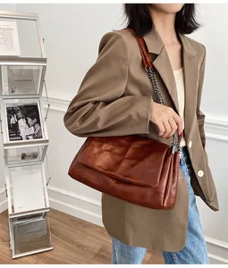 Détail du sac à bandoulière matelassé marron vintage avec chaîne dorée et texture cuir