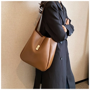 Close-up of brown matte leather bucket bag with a golden square rotating metal clasp