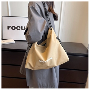 Detail of khaki nylon tote bag featuring thick black and white rope shoulder straps