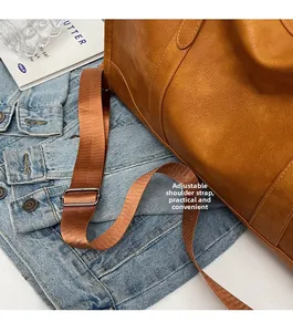 Close-up of adjustable strap and buckle on brown vintage faux leather travel bag