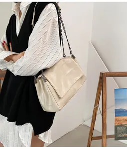 Détail du sac à bandoulière matelassé crème porté par un mannequin pour un style quotidien