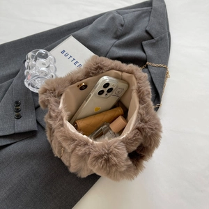 Détail d'un sac seau en fausse fourrure marron avec chaîne et doublure spacieuse