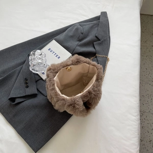 Détail d'un sac seau en peluche marron avec chaîne dorée et fermoir magnétique