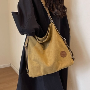 Large ginger yellow canvas tote bag with adjustable strap and circular leather logo