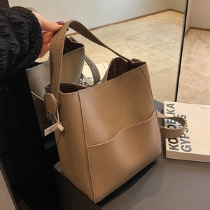Sac seau élégant en cuir gris avec large poignée et poche frontale au style minimaliste