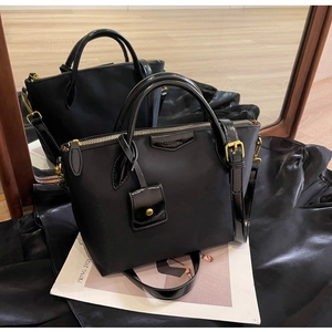 Detailed shot of black Oxford tote with gold zippers and glossy leather trim accents