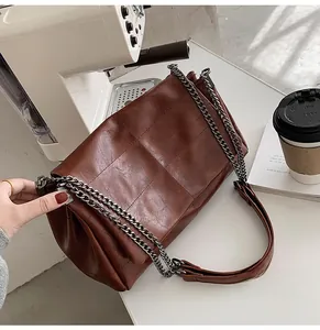 Détail du sac cabas en similicuir marron matelassé avec bandoulière en chaîne grise