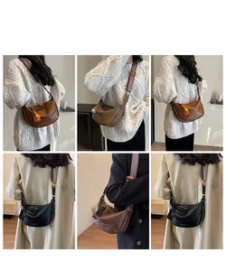 Detail view of retro crescent crossbody bag featuring textured leather and woven strap