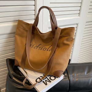 Large capacity tan canvas tote bag with brown leather handles and a long shoulder strap