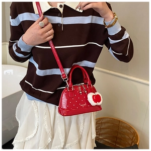 Polka dot shell bag detail with heart plush charm and red leather crossbody strap