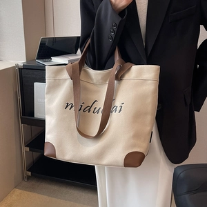 Large capacity canvas tote bag with brown leather handles and chic artistic lettering