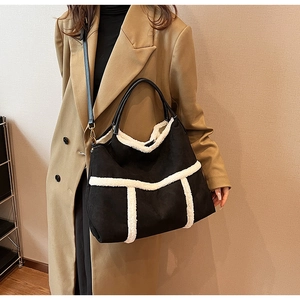 Mannequin portant un grand sac cabas noir mat avec bordure en fausse fourrure blanche chic