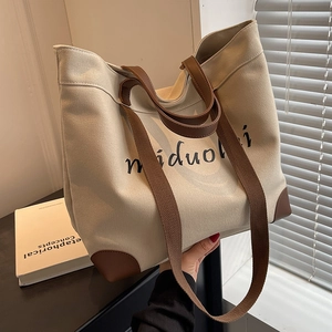 Minimalist canvas tote bag in off-white with brown straps and artistic text for women
