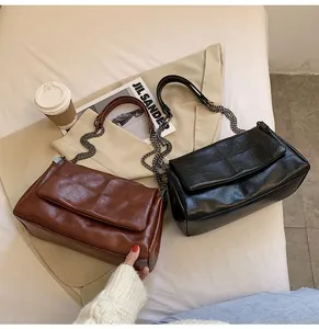 Détail des sacs à rabat rectangulaires avec gaufrage carré et bandoulière en chaîne métallique