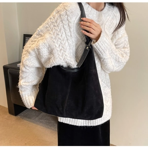 Detail of black matte suede tote bag worn with white sweater for an autumn look