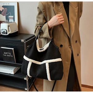 Vue détaillée du grand sac cabas en daim noir avec bordure en polaire blanche et anses