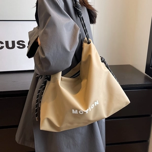 Khaki large nylon tote bag with white MOTION print and knotted rope shoulder strap