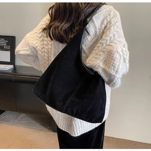 Minimalist black matte tote bag styled with a white cable knit sweater for an autumn look