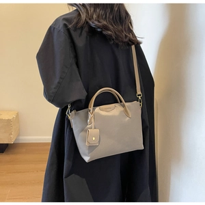 Close-up of gray Oxford tote bag with slim handles and matching mini pouch accessory