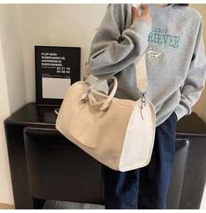 Close-up of beige large capacity travel bag featuring adjustable strap and logo pocket