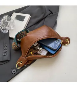 Practical internal storage of brown leather crossbody bag with ethnic patterned strap
