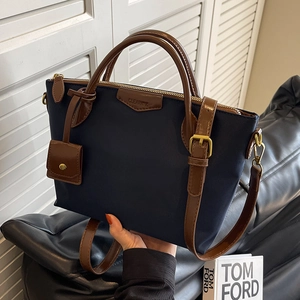 Large navy blue nylon tote bag with brown leather handles and adjustable shoulder strap