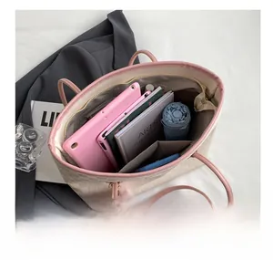 Interior view of checkered tote bag filled with iPad, notebook, and folding umbrella
