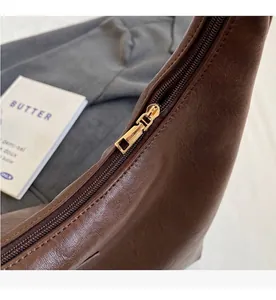 Détail de la fermeture éclair dorée et du cuir grainé sur un grand sac fourre-tout