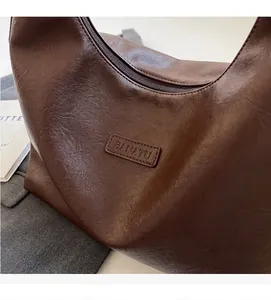 Détail du sac cabas marron foncé avec texture en cuir vintage et logo de marque