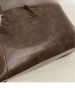 Close-up of vintage brown tote bag showing durable leather texture and fine stitching