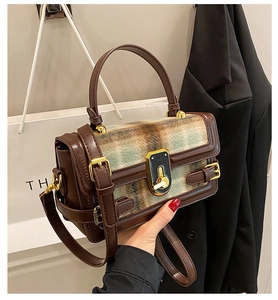 Detailed view of vintage plaid pattern crossbody bag with metallic rotary lock and strap