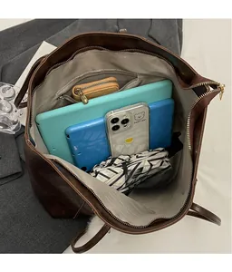 Detailed view of dark brown tote bag interior showing large capacity and zipper pocket