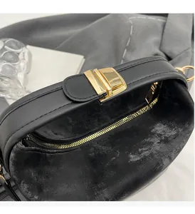 Détail du sac en cuir noir mat avec fermoir doré élégant et fermeture à glissière fluide