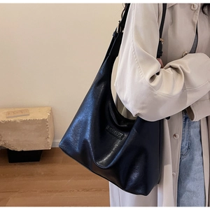 Gros plan du grand sac cabas Hobo noir avec bandoulière réglable sur un mannequin