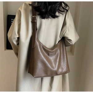 Détail de la boucle en métal réglable et de la bandoulière sur le sac fourre-tout