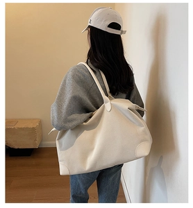 Dettaglio della borsa tote in velluto a coste beige con trama a coste e toppe in pelle