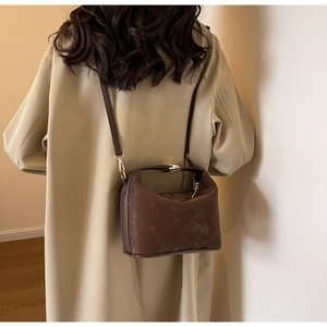 Vue détaillée du sac à bandoulière vintage marron avec boucle dorée et texture dépolie